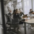 Professionals in a meeting room engaged in a collaborative business discussion.