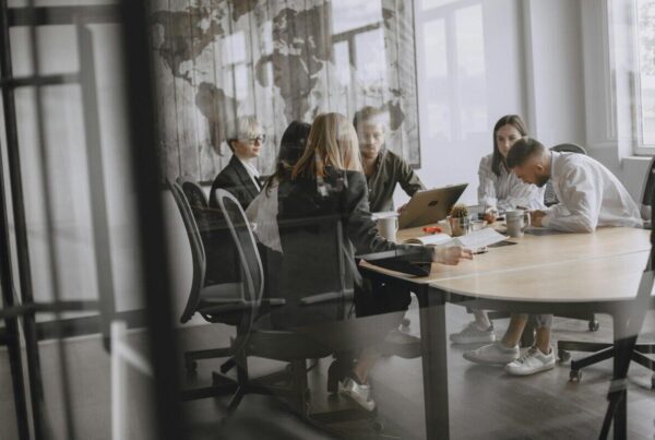 Professionals in a meeting room engaged in a collaborative business discussion.