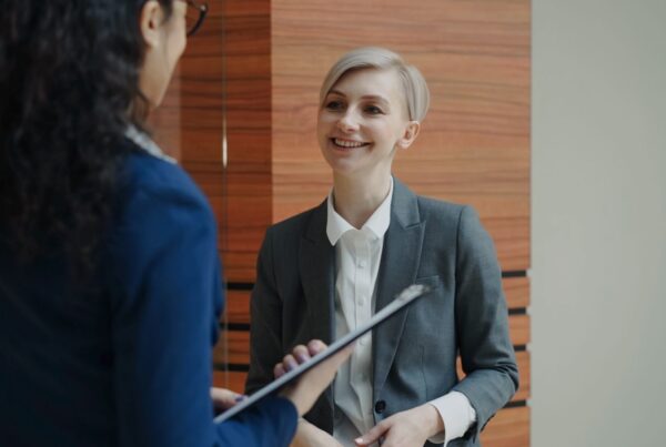 Two professionals having a conversation during a business meeting indoors.