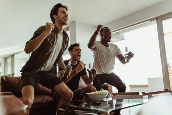 a group of men sitting on a couch and laughing