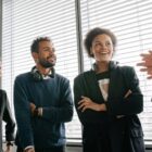 Group of diverse colleagues with headsets enjoying a conversation in a bright office setting.