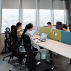 Spacious contemporary office space with employees working on laptops in a high-rise building.