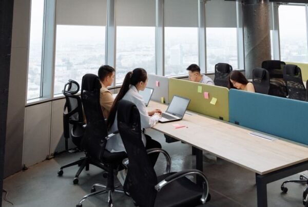 Spacious contemporary office space with employees working on laptops in a high-rise building.